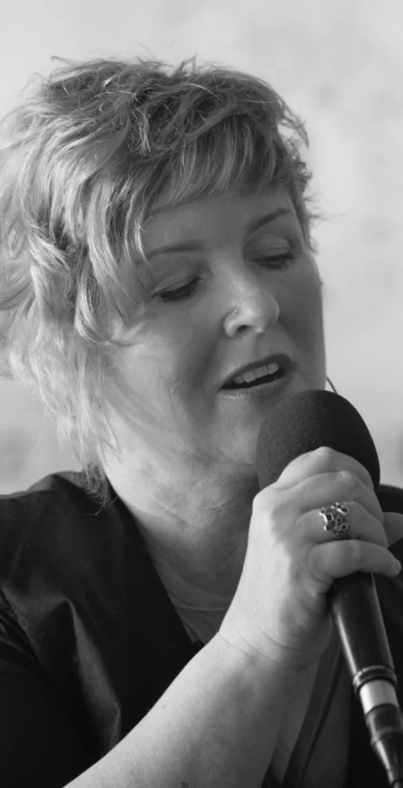 Andrea Betche singt in ein Handmikrofon